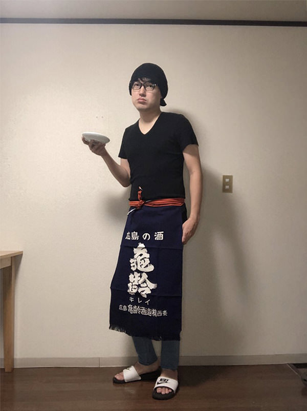 メニュー表が筆で書いてある居酒屋の店員